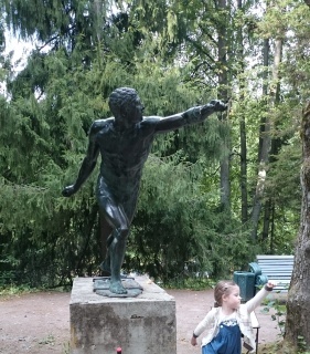 Дочка Вера показывает пародию на статую в парке Павловска (под Питером)